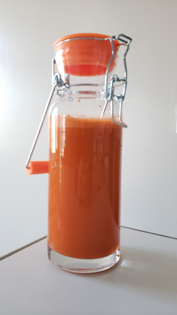 Carrot juice in a glass bottle