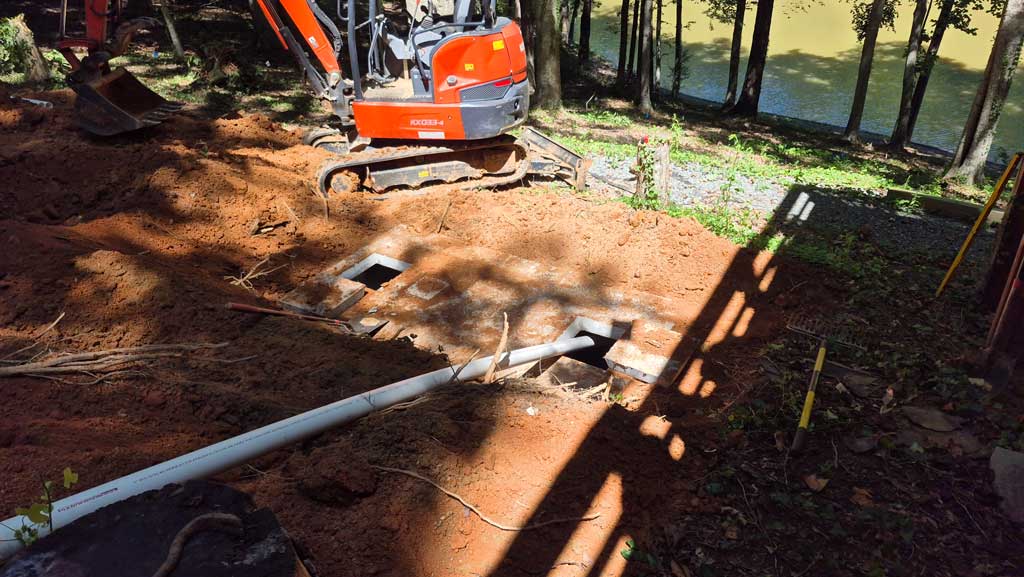 Filling new septic tank with water to keep it secured to the ground.