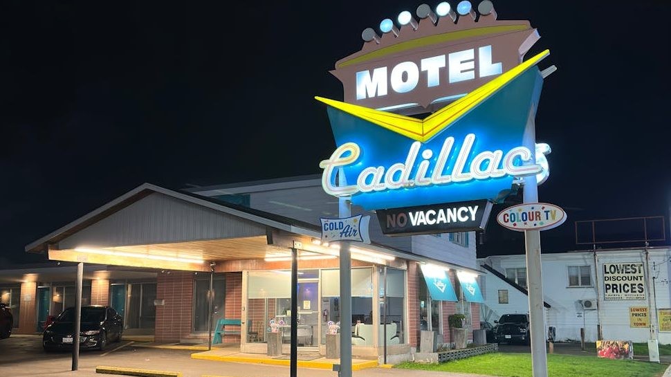 vintage cadillac motel sign at night